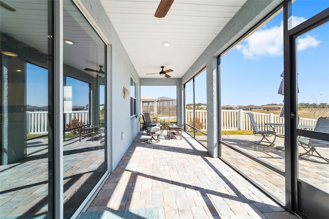 unfurnished sunroom with ceiling fan