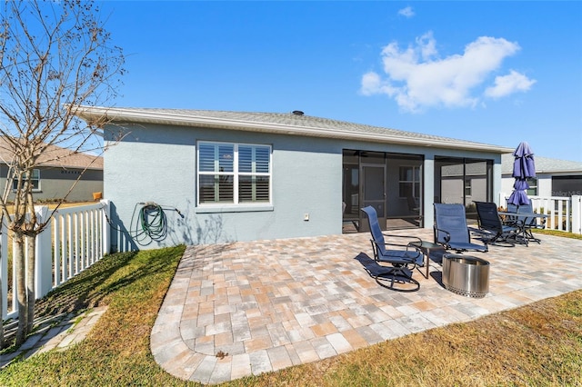 rear view of property featuring a sunroom and a patio area