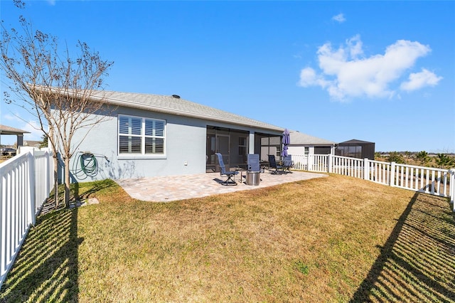 rear view of house with a sunroom, a patio, and a lawn