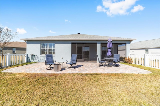 back of house with a patio and a lawn