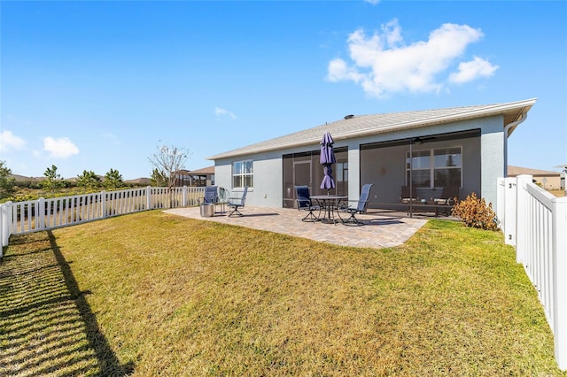 rear view of house with a yard and a patio