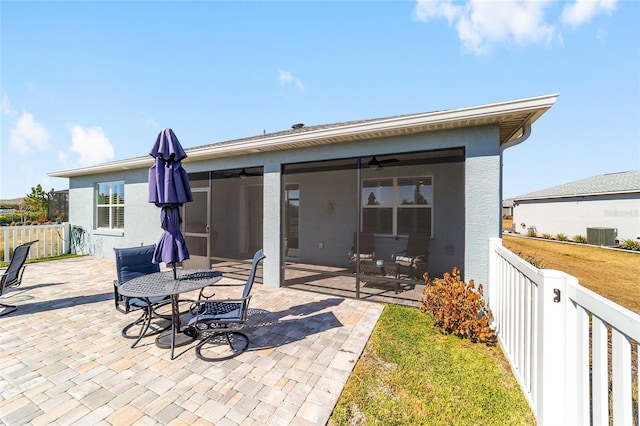 back of property featuring central AC unit, a sunroom, a patio, and ceiling fan