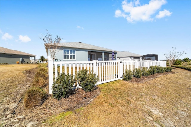 back of property featuring a lawn and a sunroom