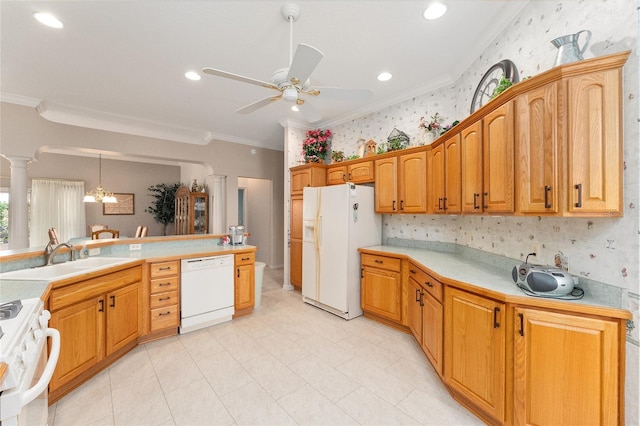 kitchen with pendant lighting, sink, white appliances, ornamental molding, and ornate columns