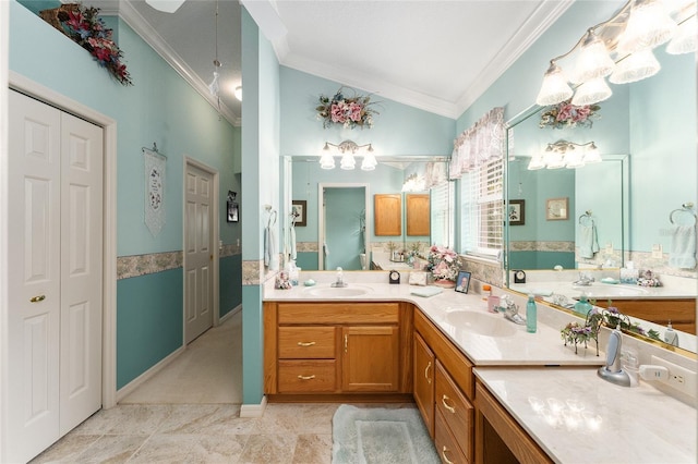 bathroom with crown molding, vanity, and vaulted ceiling