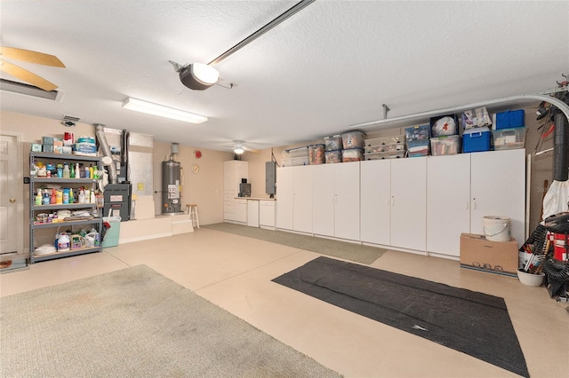 garage with a garage door opener, gas water heater, electric panel, and ceiling fan