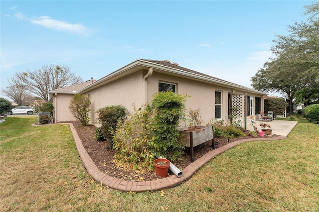 view of home's exterior featuring a patio and a lawn