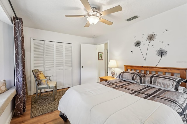 bedroom featuring ceiling fan, light hardwood / wood-style floors, and a closet