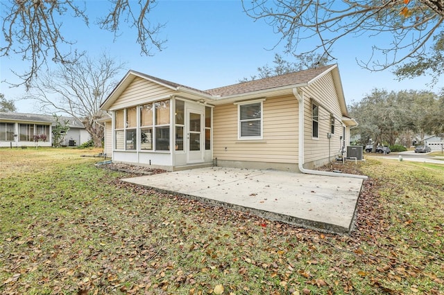 rear view of house with cooling unit, a yard, a sunroom, and a patio