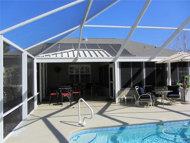 view of swimming pool featuring glass enclosure and a patio area