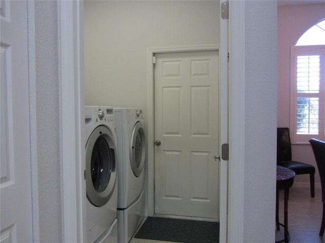 laundry room featuring washing machine and dryer and dark tile patterned floors