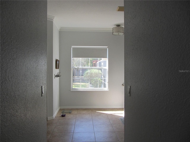 empty room featuring light tile patterned flooring and crown molding