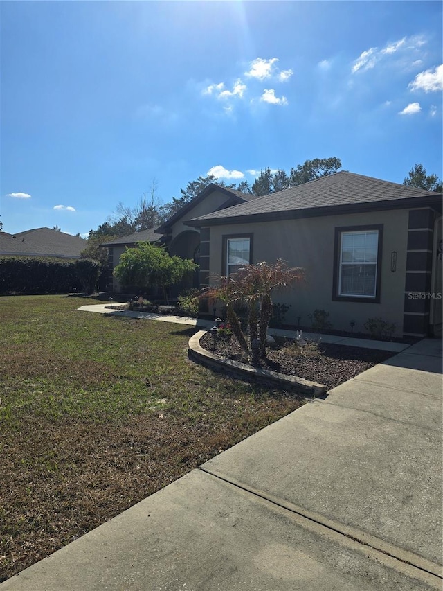 view of side of home with a yard