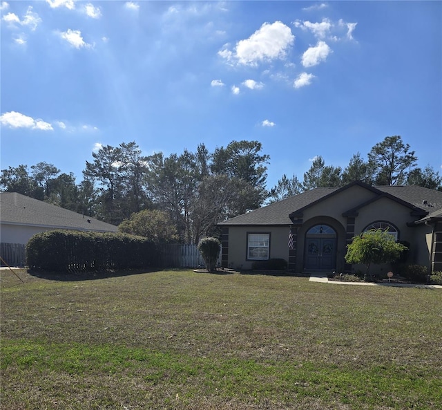 ranch-style home with french doors and a front lawn