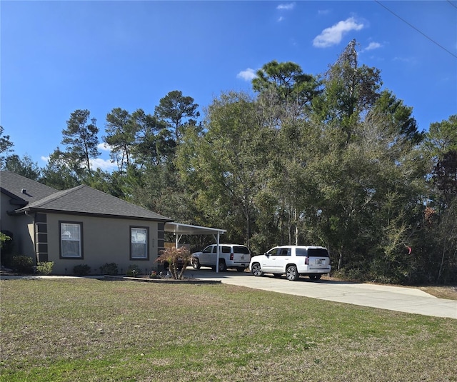 view of side of home featuring a yard and a carport