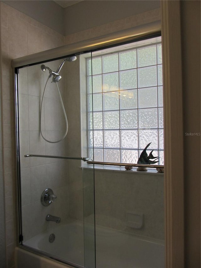 bathroom with combined bath / shower with glass door