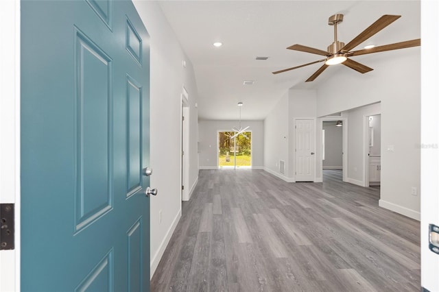 interior space featuring baseboards, ceiling fan, vaulted ceiling, and wood finished floors