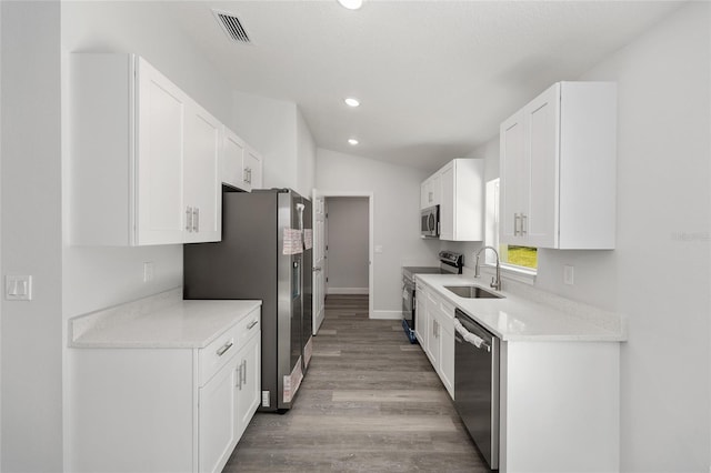 kitchen featuring visible vents, appliances with stainless steel finishes, a sink, white cabinets, and light wood-style floors