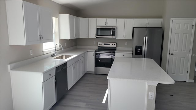 kitchen featuring white cabinetry, sink, stainless steel appliances, and a kitchen island