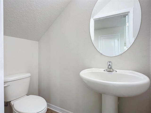 35 Wood Acre Ln, Palm Coast, FL 32164 - bathroom with lofted ceiling, a textured ceiling, and toilet
