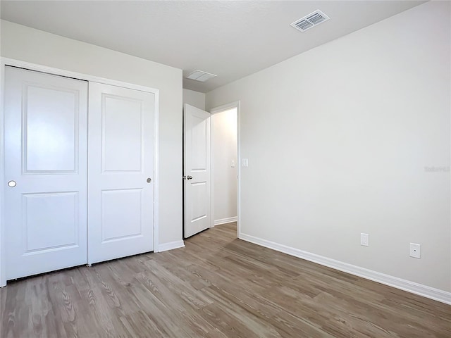 35 Wood Acre Ln, Palm Coast, FL 32164 - unfurnished bedroom with light wood-type flooring and a closet