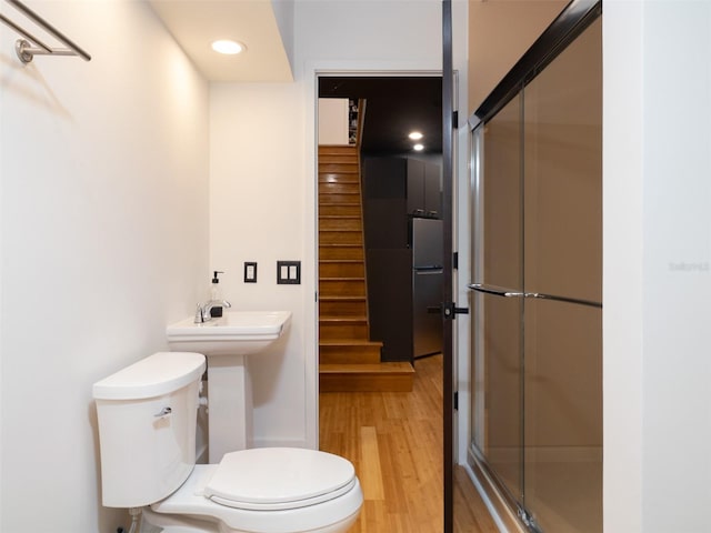 bathroom featuring an enclosed shower, hardwood / wood-style flooring, and toilet