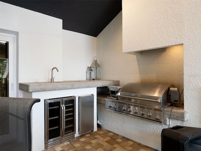 view of patio with wine cooler, an outdoor kitchen, and a grill