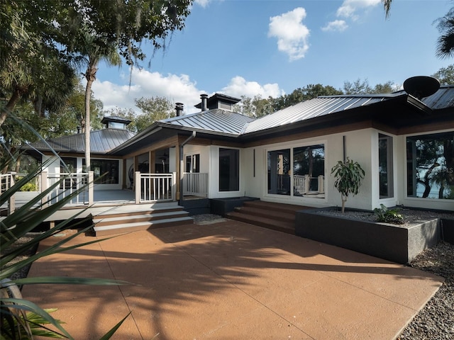 rear view of house with a patio area and a porch