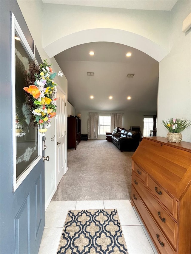 foyer with vaulted ceiling and light colored carpet