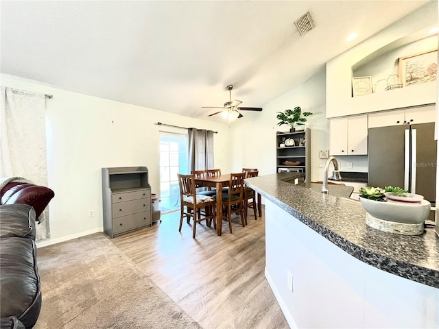 kitchen featuring stainless steel refrigerator, sink, white cabinets, ceiling fan, and light hardwood / wood-style floors