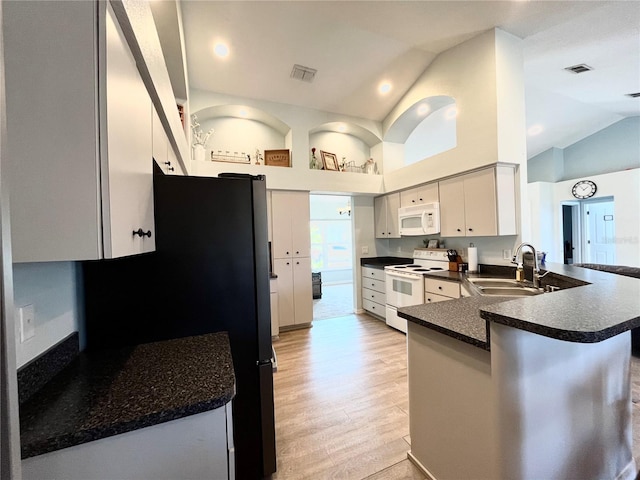 kitchen featuring sink, white appliances, high vaulted ceiling, light hardwood / wood-style floors, and kitchen peninsula