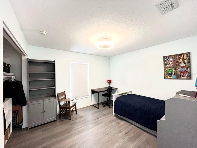 bedroom featuring hardwood / wood-style floors and a textured ceiling