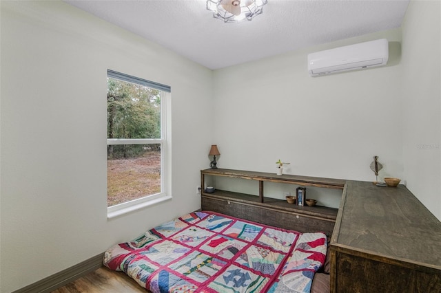 bedroom with hardwood / wood-style flooring and a wall mounted AC