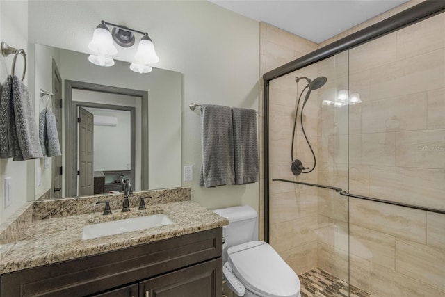 bathroom with vanity, toilet, and a shower with shower door