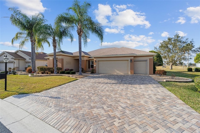 single story home with a garage and a front lawn