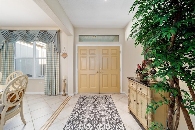 foyer entrance featuring light tile patterned floors and baseboards