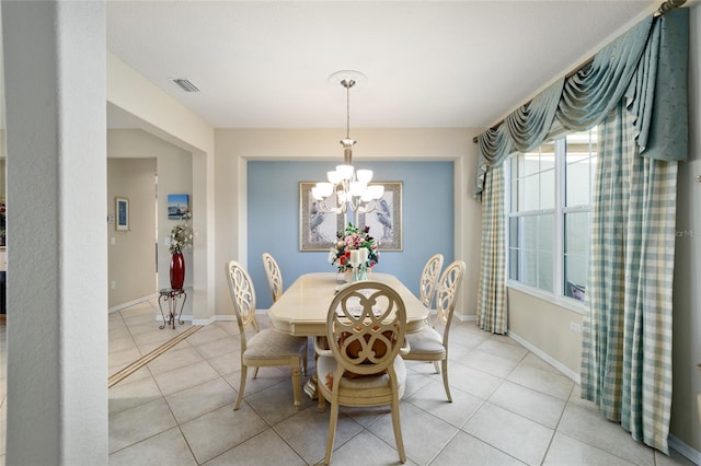 dining area with light tile patterned flooring, an inviting chandelier, and baseboards