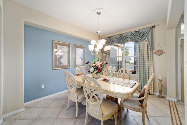 dining area with light tile patterned floors, baseboards, and a notable chandelier