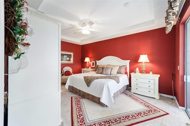 bedroom with ceiling fan, carpet, a raised ceiling, and baseboards