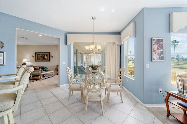 dining space with baseboards, light tile patterned floors, and a notable chandelier