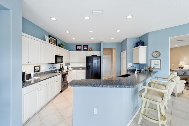 kitchen featuring black appliances, dark countertops, a peninsula, and visible vents