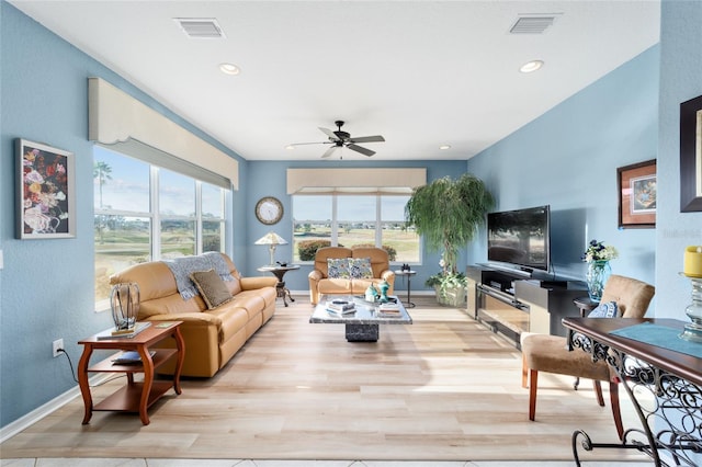 living area with visible vents, a wealth of natural light, and wood finished floors