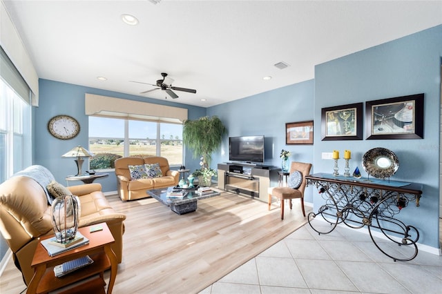 living room with ceiling fan, wood finished floors, visible vents, and a healthy amount of sunlight