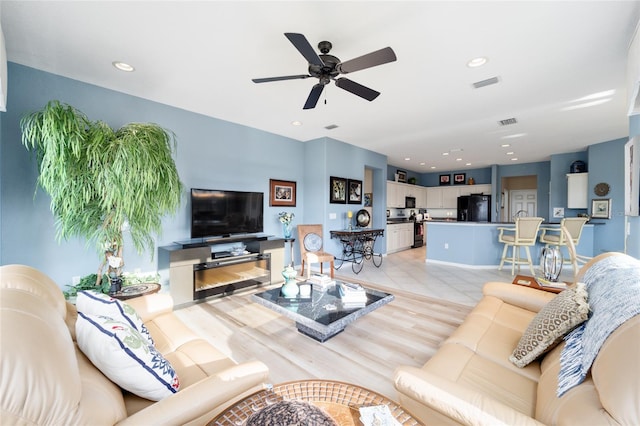 living area featuring light tile patterned floors, visible vents, and recessed lighting