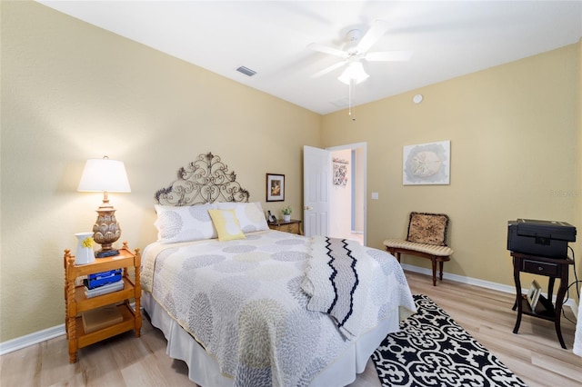 bedroom with baseboards, ceiling fan, visible vents, and light wood finished floors