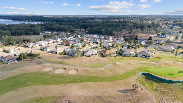 drone / aerial view featuring a residential view, view of golf course, and a water view