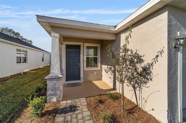 view of exterior entry featuring a lawn