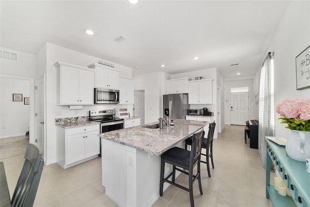 kitchen with sink, a center island with sink, white cabinets, and appliances with stainless steel finishes