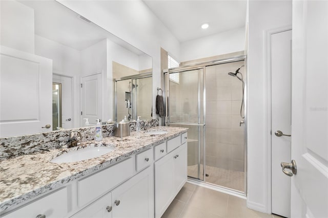 bathroom featuring walk in shower, vanity, and tile patterned flooring