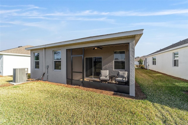 back of house featuring a lawn, a sunroom, and central air condition unit